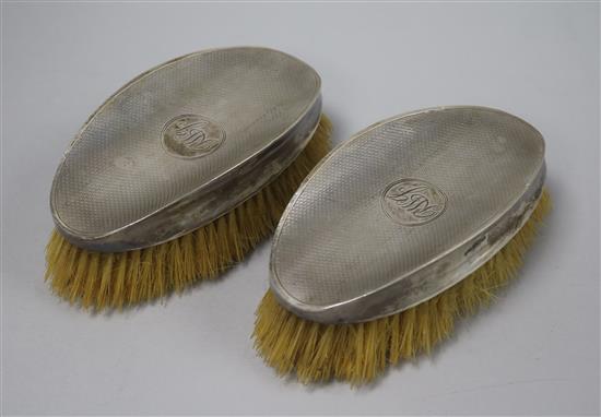 A pair of 1920s engine turned silver mounted clothes brushes by Walker & Hall, Sheffield, 1929, 14cm.